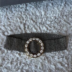 🟢COWRY. Silver metal elastic belt with a brass and shell accent. One size